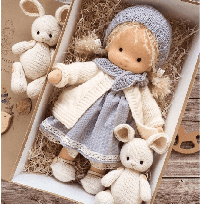Handmade Waldorf doll in knitted clothing with soft features and character accessories