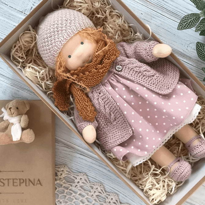 Handmade Waldorf doll in knitted clothing with soft features and character accessories