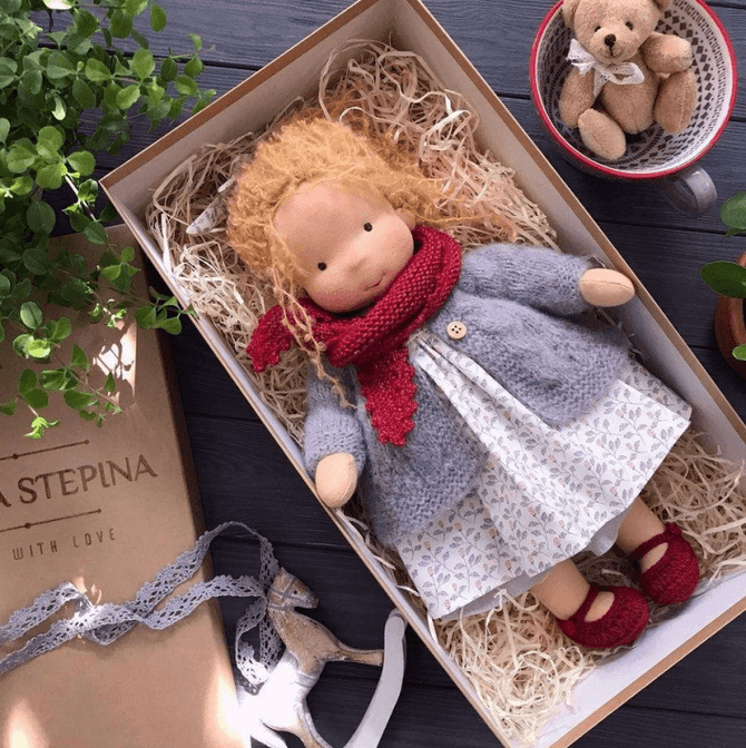 Handmade Waldorf doll in knitted clothing with soft features and character accessories