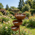 Three-tier brown bird bath with three bowls on a garden stake