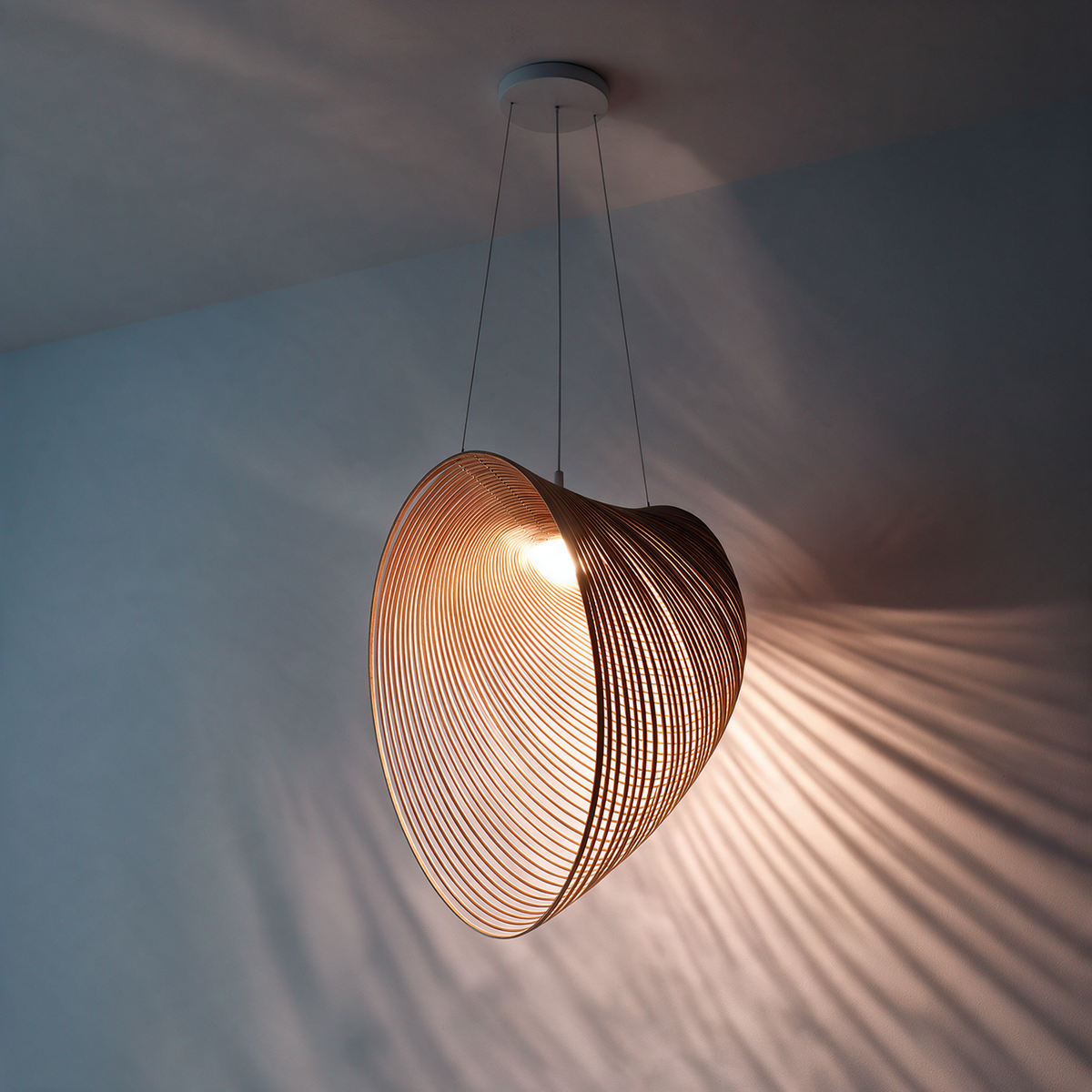 Sculptural pendant light with a curved open wire shade