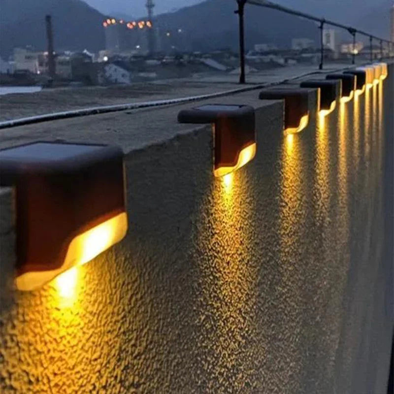 Black solar stair light illuminating outdoor steps and walls