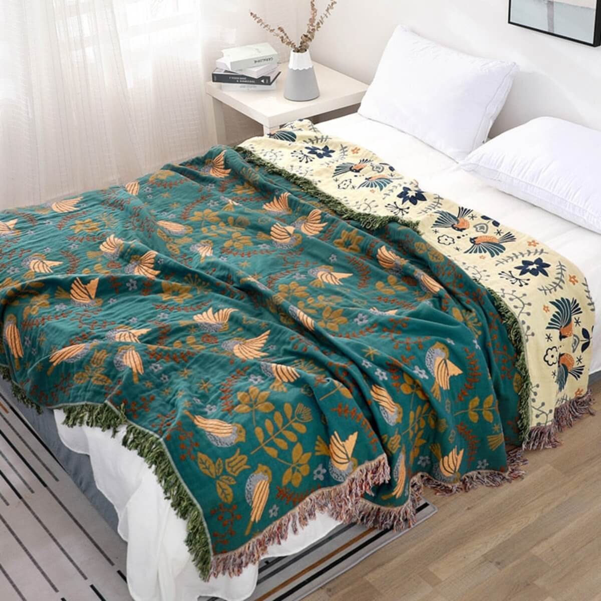 Reversible botanical patterned blanket with contrasting bird design and fringed edges