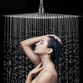 Ultra-thin silver rectangular rainfall shower head releasing an overhead water flow