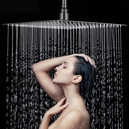 Ultra-thin silver rectangular rainfall shower head releasing an overhead water flow