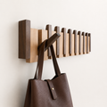 Wall mounted wooden coat rack with alternating slats and folding hooks