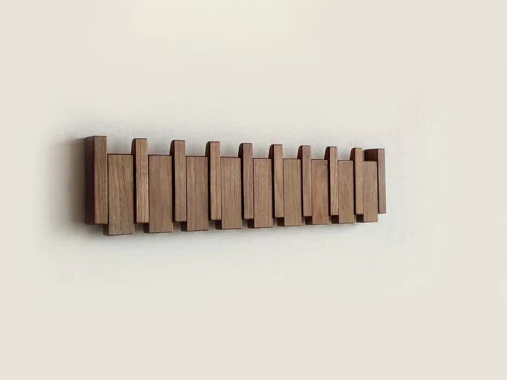 Wall mounted wooden coat rack with alternating slats and folding hooks