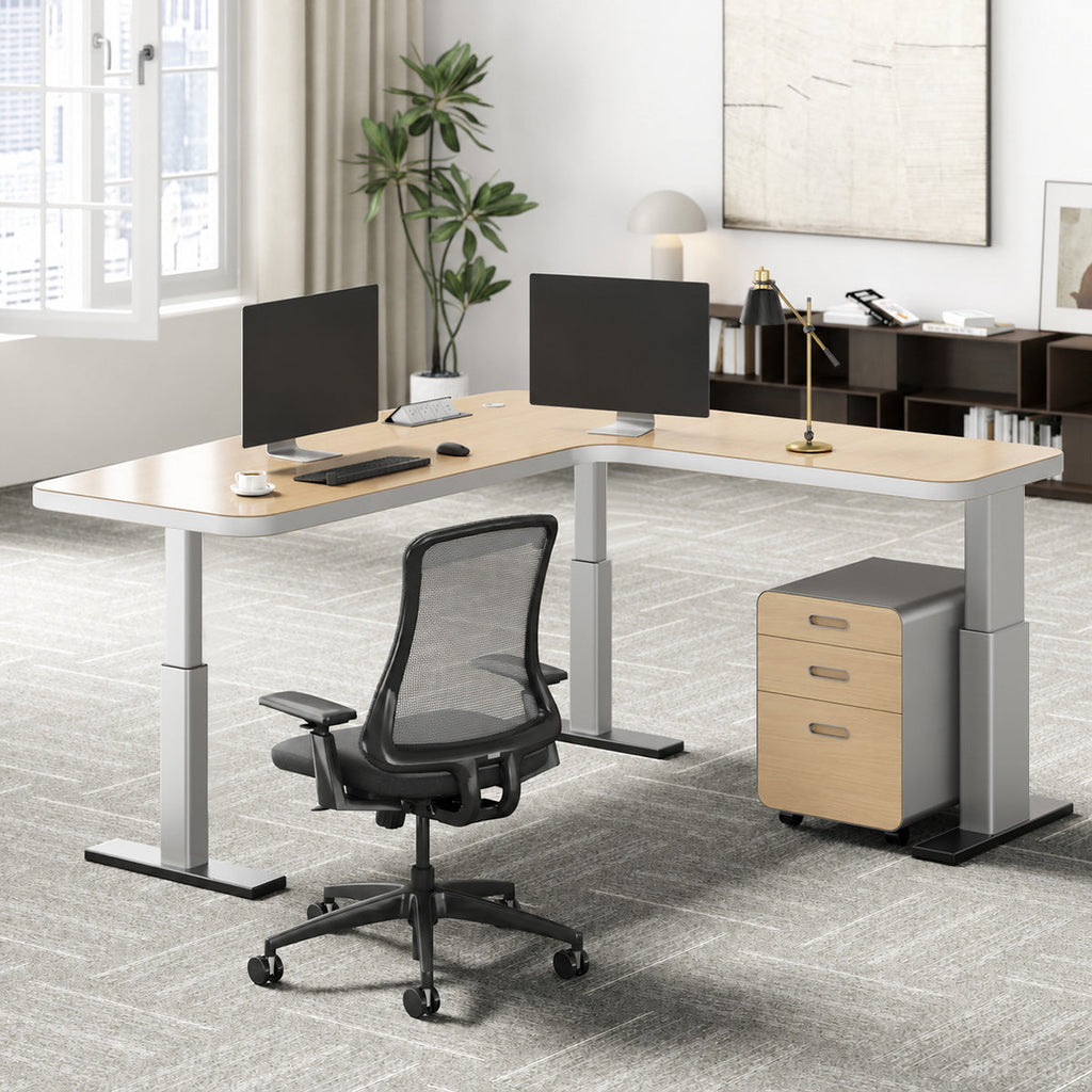 L-shaped natural wood-effect sit-stand office desk with power hub and mobile three-drawer cabinet