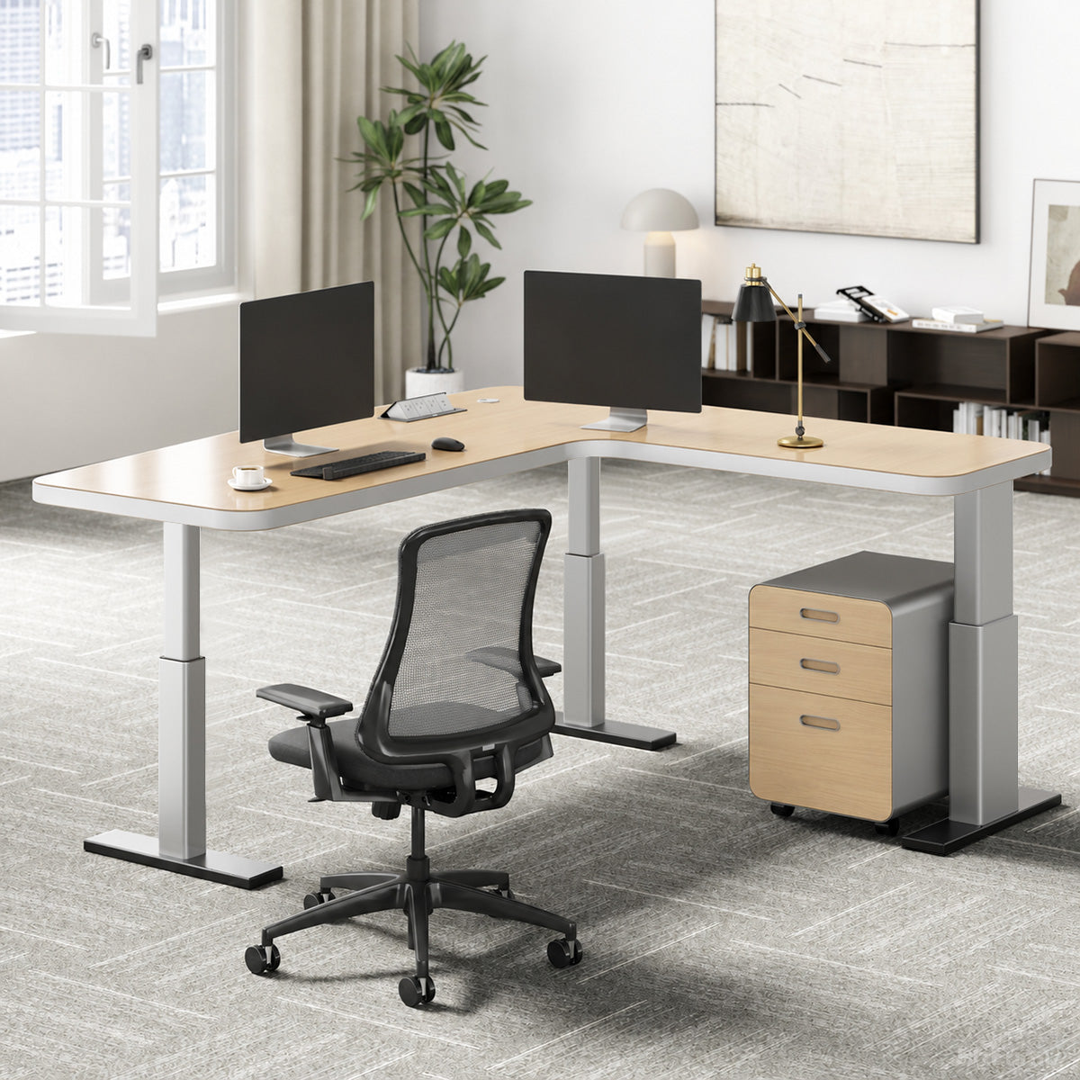 L-shaped natural wood-effect sit-stand office desk with power hub and mobile three-drawer cabinet