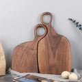 Brown walnut cutting board with shaped handle and rounded hanging hole