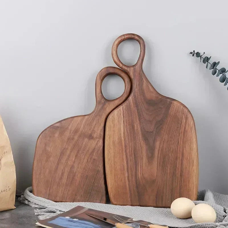 Brown walnut cutting board with shaped handle and rounded hanging hole