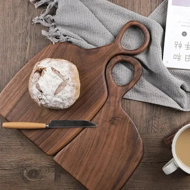 Brown walnut cutting board with shaped handle and rounded hanging hole