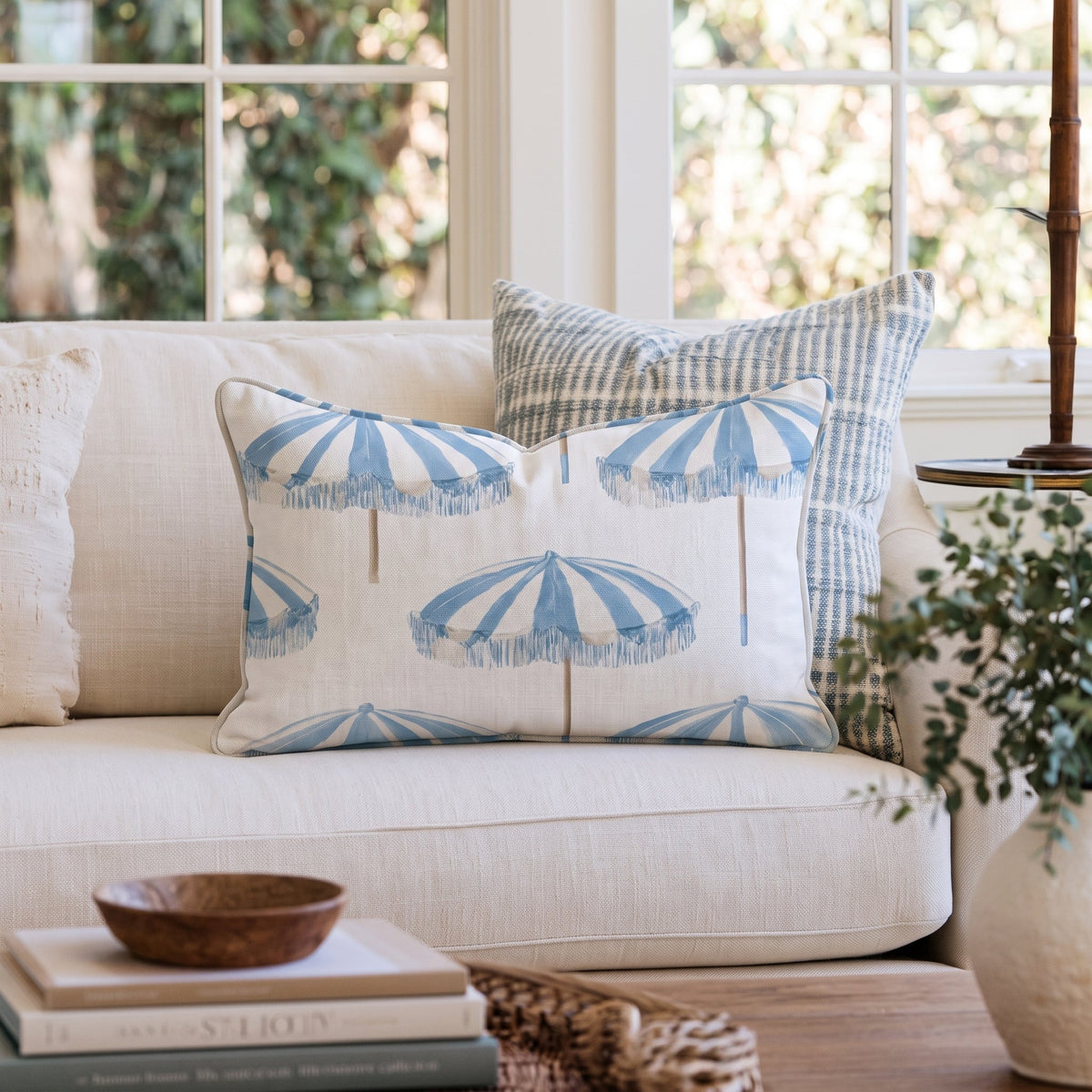 White square throw pillow with a blue umbrella pattern