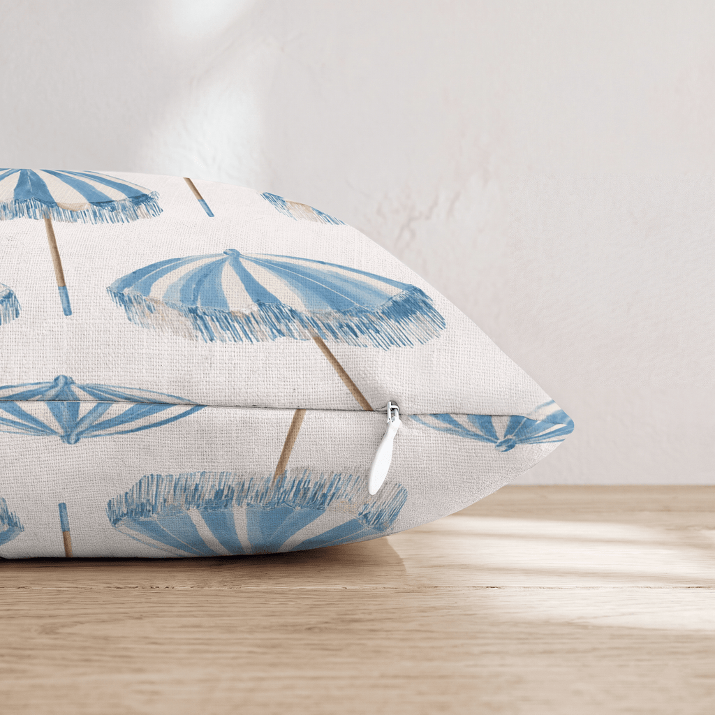 White square throw pillow with a blue umbrella pattern