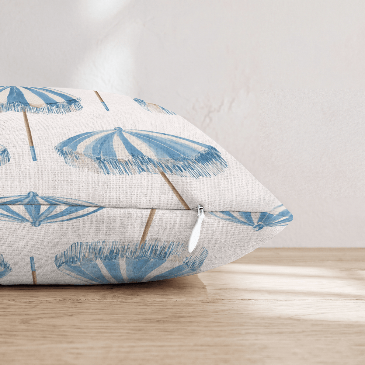 White square throw pillow with a blue umbrella pattern