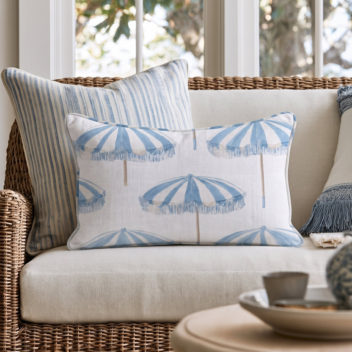 White square throw pillow with a blue umbrella pattern