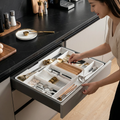 White adjustable cutlery drawer organiser with multiple kitchen utensil compartments